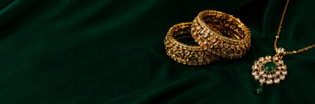 Gold bangles and emerald jewellery on emerald silk